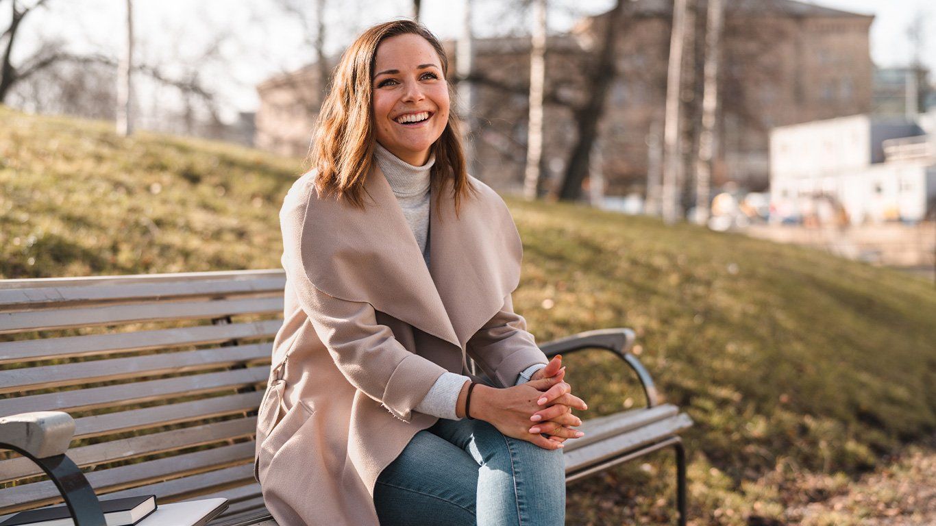 Ung dame på en benk i en park